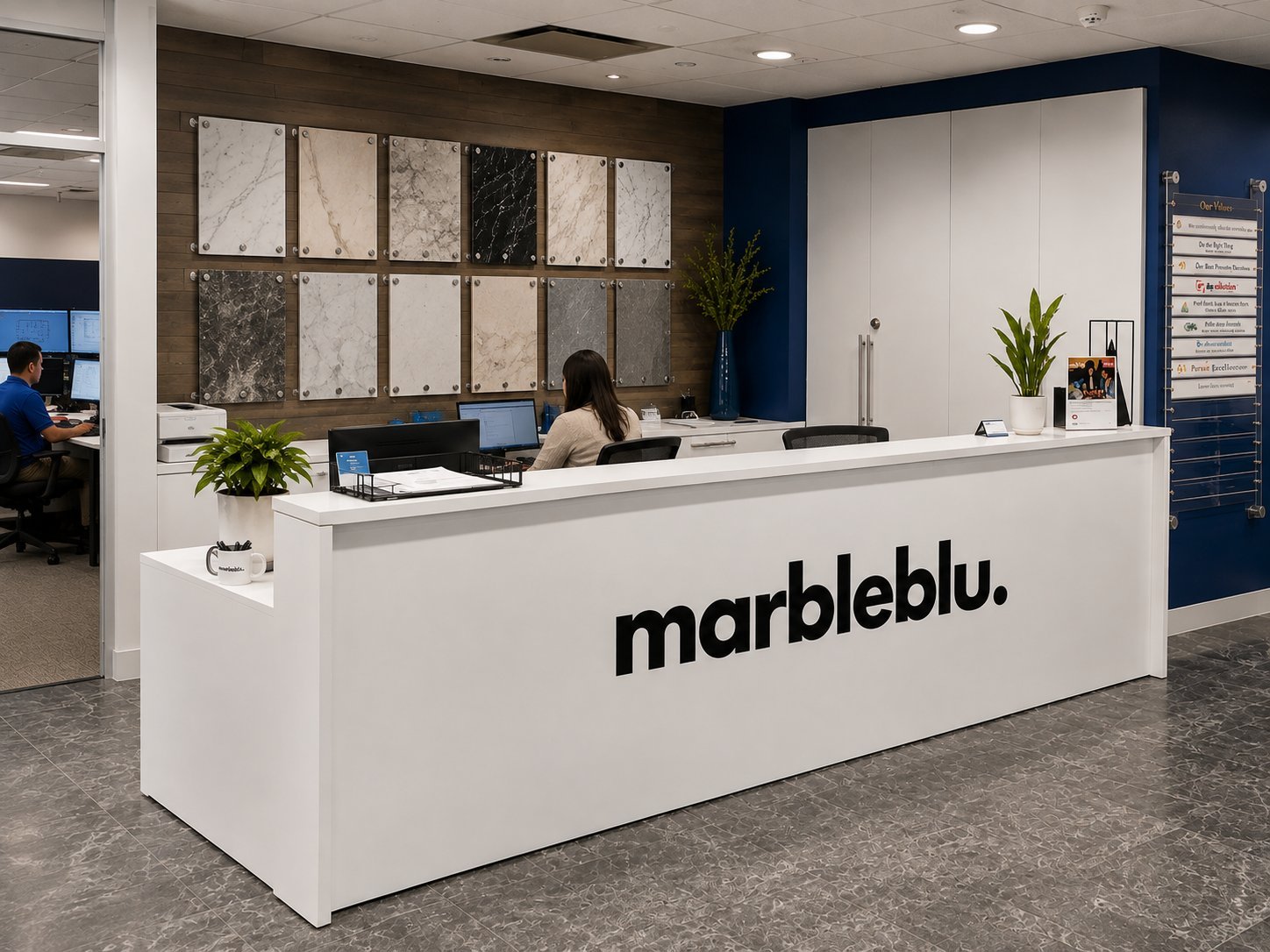 Modern marbleblue showroom reception desk with employee, stone samples display, and navy blue accent wall.